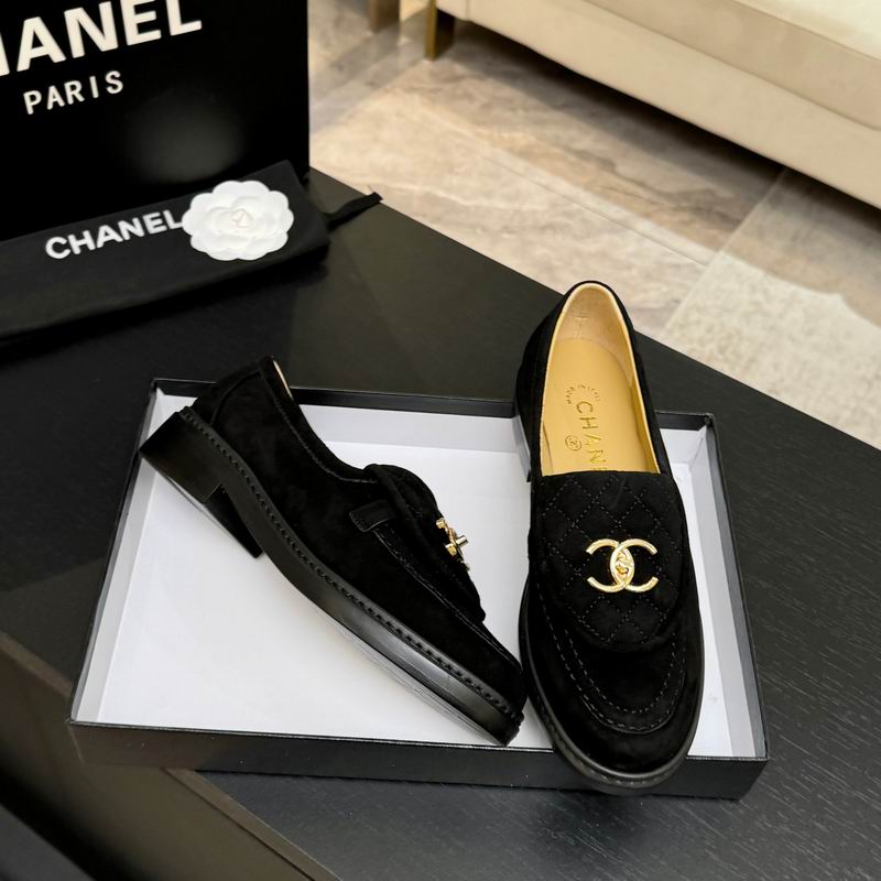 Chanel CC Logo quilted black suede loafers with gold-tone interlocked CC hardware, displayed in Chanel branded box