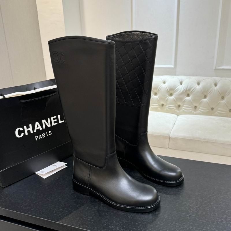 Chanel black calfskin quilted knee-high riding boots displayed on dark surface with Chanel Paris shopping bag